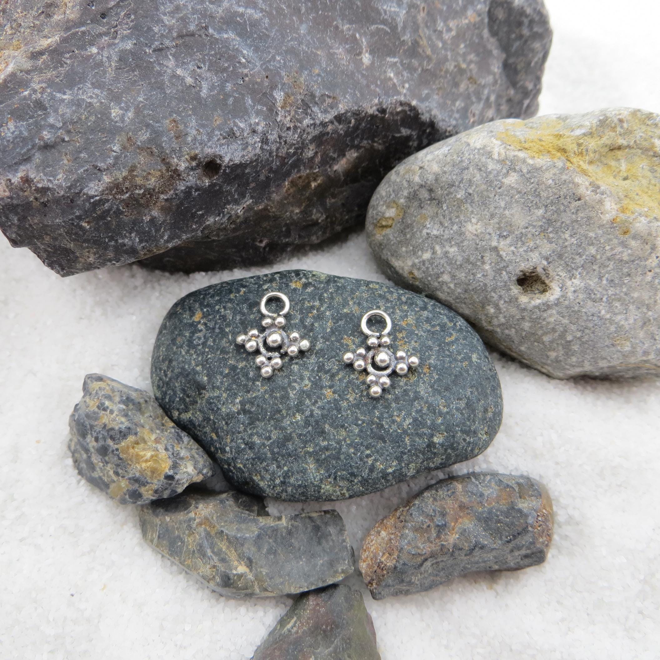 May include: A white ceramic mug with a black handle and the text "But First, Coffee" in a black, handwritten-style font. The mug is on a white surface.